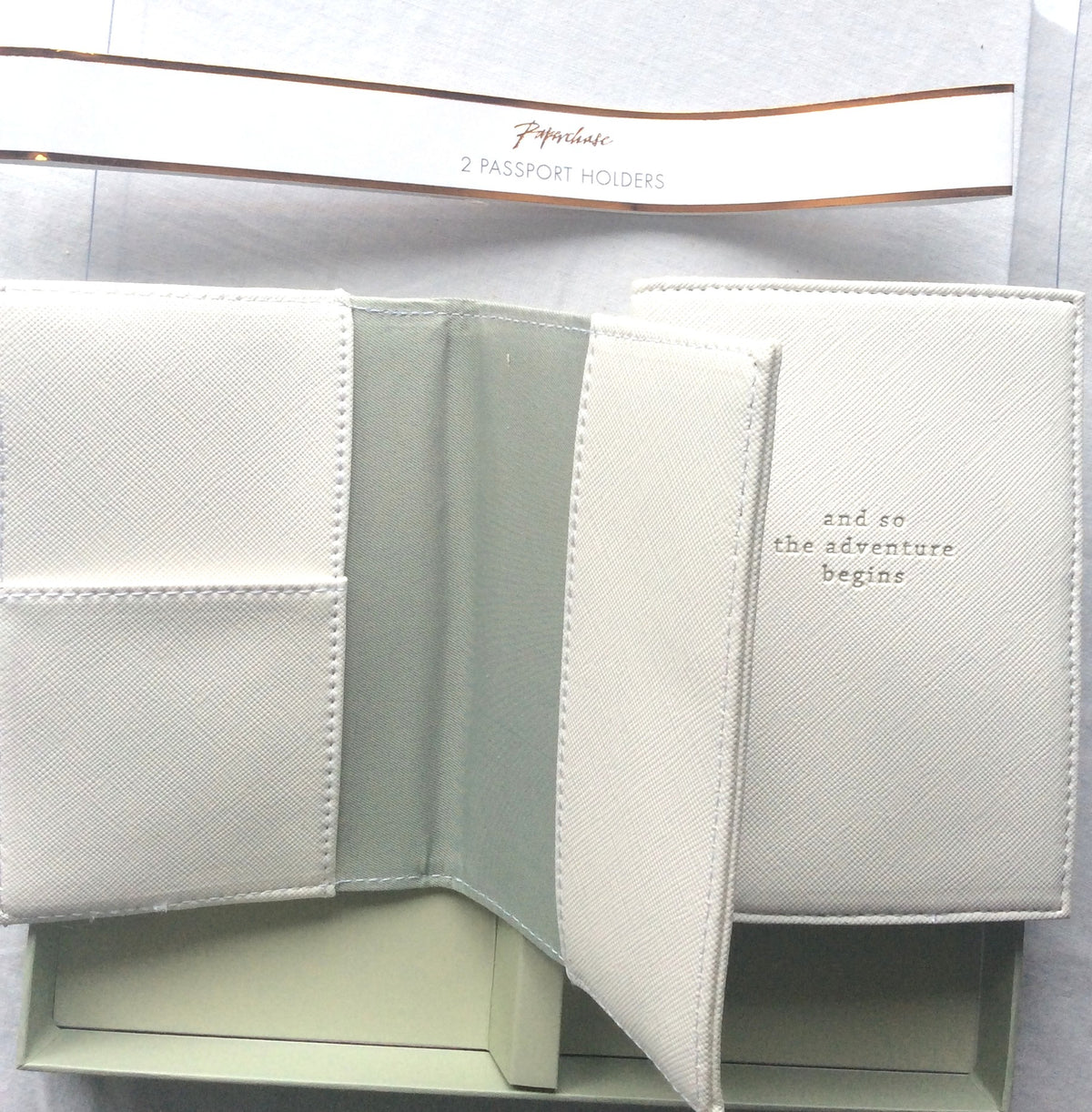 Two textured passport holders opened to show their interior compartments
